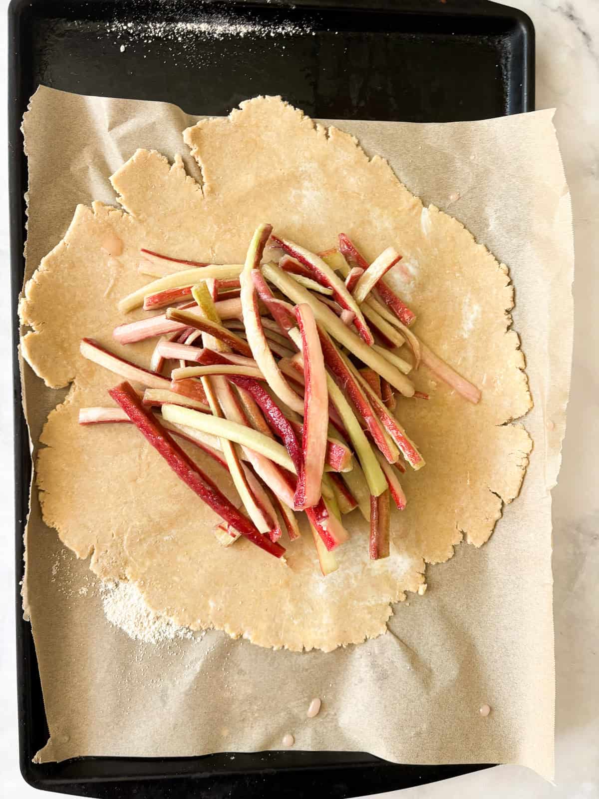 This rhubarb galette features a flaky, whole-grain crust folded around a jammy filling. Rhubarb's flavor truly shines in this rustic bake. Rhubarb filling added to galette dough.