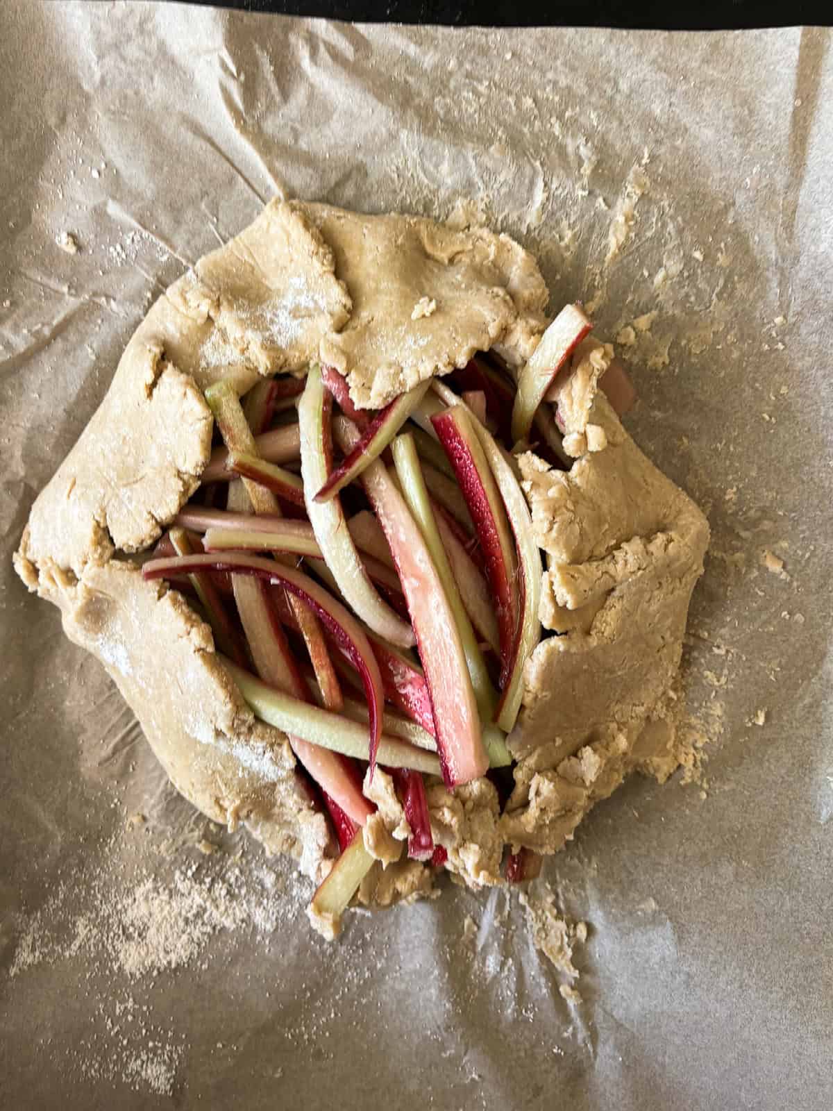 This rhubarb galette features a flaky, whole-grain crust folded around a jammy filling. Rhubarb's flavor truly shines in this rustic bake. The assembled rhubarb galette before the oven.