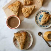 Strawberry rhubarb scones next to a cup of coffee.