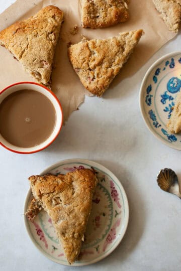 Strawberry rhubarb scones next to a cup of coffee.