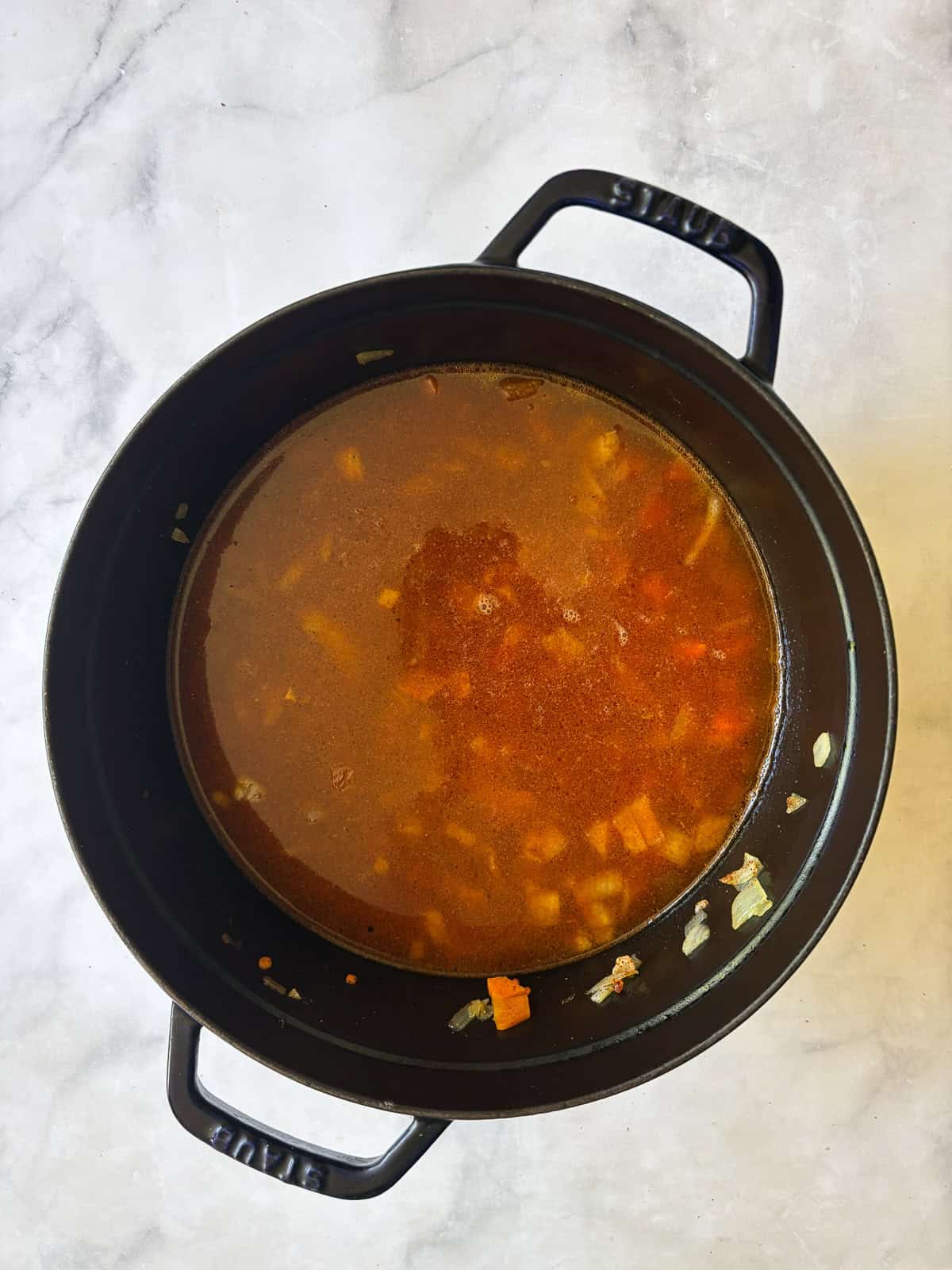 A hearty vegetarian red lentil stew that's packed with vegetables to make a satisfying dinner. Easy to adapt and make-ahead friendly. Broth is added to the stew pot.