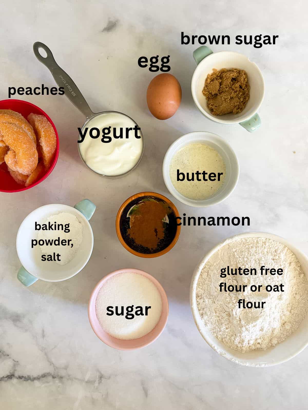 Yogurt, whole grains, and juicy peaches are swirled together with brown sugar in these tender and good-for-you gluten free peach muffins. Ingredients for gluten free peach muffins are text-labeled.