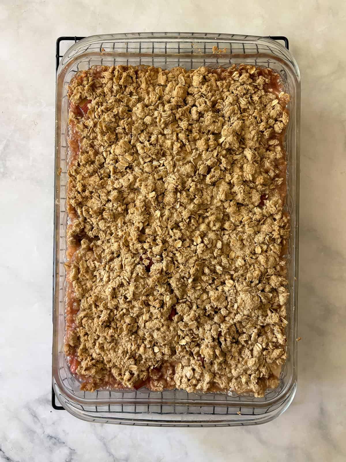 A jammy apple rhubarb crisp pairs seasonal rhubarb with sweet apples. Make the buttery oat topping gluten-free or use whole wheat flour. A baked apple rhubarb crisp in the pan.