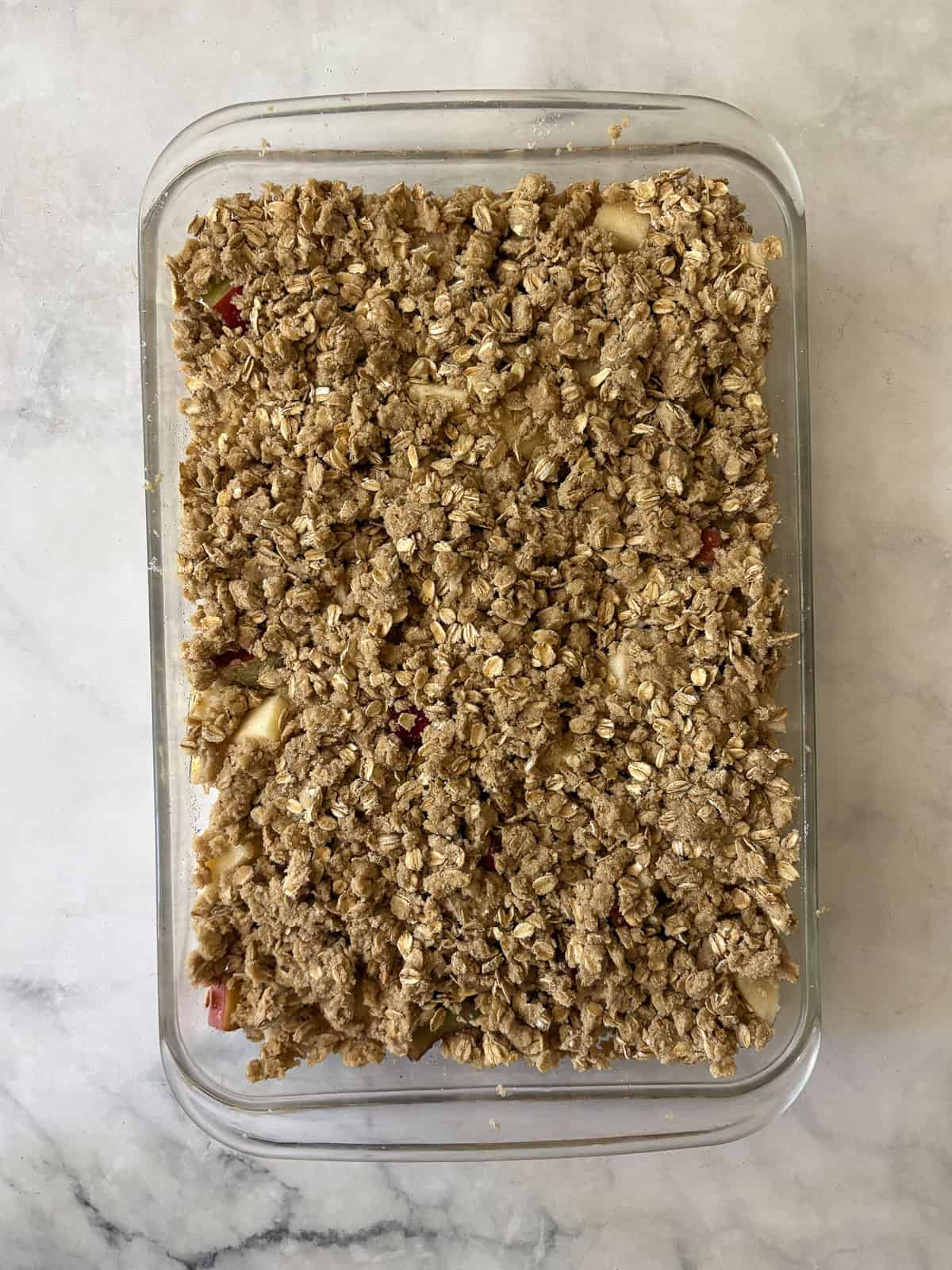 A jammy apple rhubarb crisp pairs seasonal rhubarb with sweet apples. Make the buttery oat topping gluten-free or use whole wheat flour. An apple rhubarb crisp in the pan.