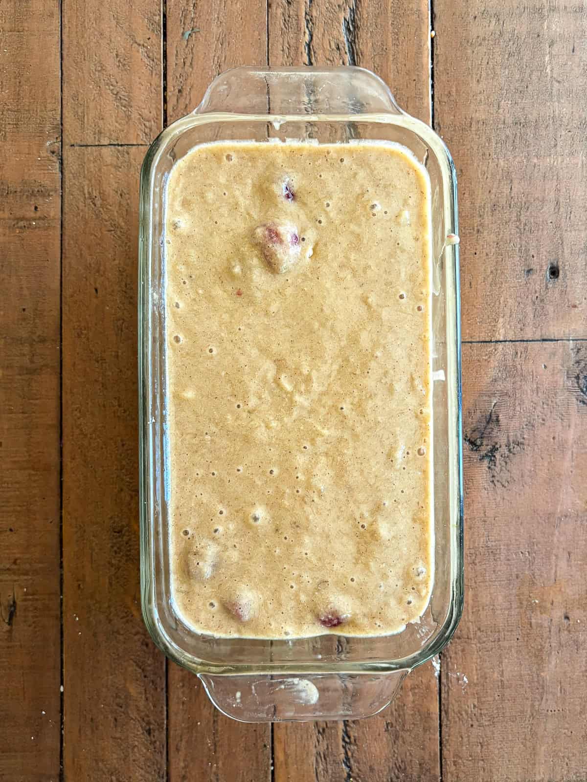 An uptick on a classic, this whole-grain raspberry banana bread features a soft, tender bread studded with juicy pockets of raspberries. Batter for banana raspberry bread in a loaf pan.