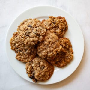 A white plate of chocolate chip oatmeal cookies.