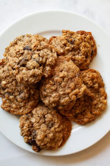 A white plate of chocolate chip oatmeal cookies.