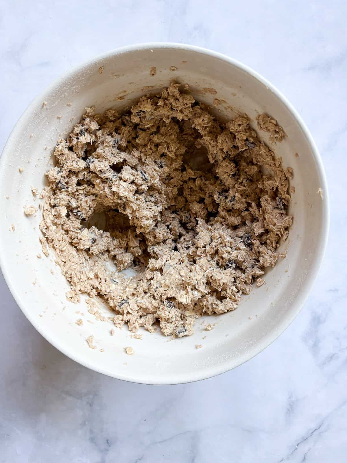 Soft and chewy-crisp chocolate chip oatmeal cookies are packed with the good stuff - butter, rolled oats, whole grain flour, and chocolate! Chocolate chip oatmeal cookies dough in a bowl.