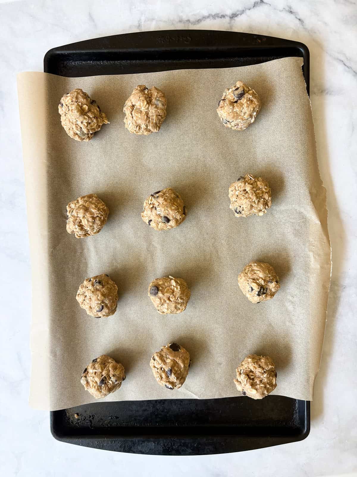 Soft and chewy-crisp chocolate chip oatmeal cookies are packed with the good stuff - butter, rolled oats, whole grain flour, and chocolate! Chocolate chip oatmeal cookies are portioned out.