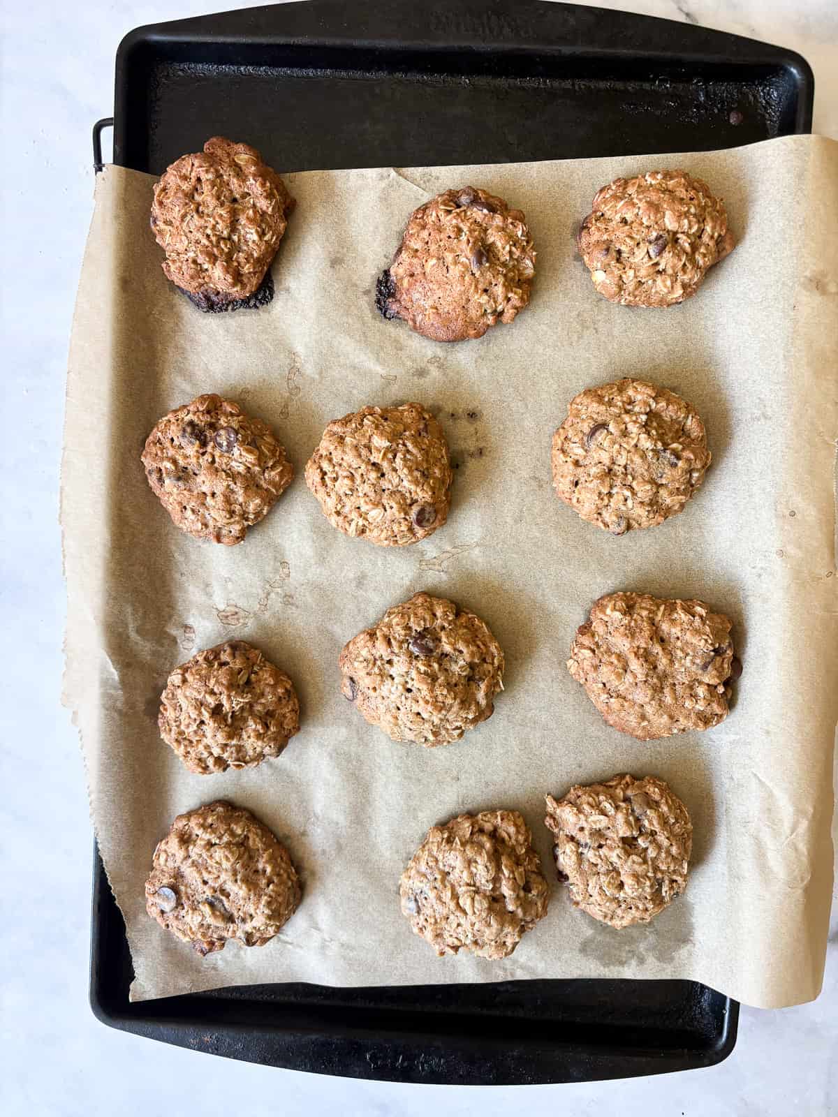 Soft and chewy-crisp chocolate chip oatmeal cookies are packed with the good stuff - butter, rolled oats, whole grain flour, and chocolate! A baked tray of chocolate chip oatmeal cookies.