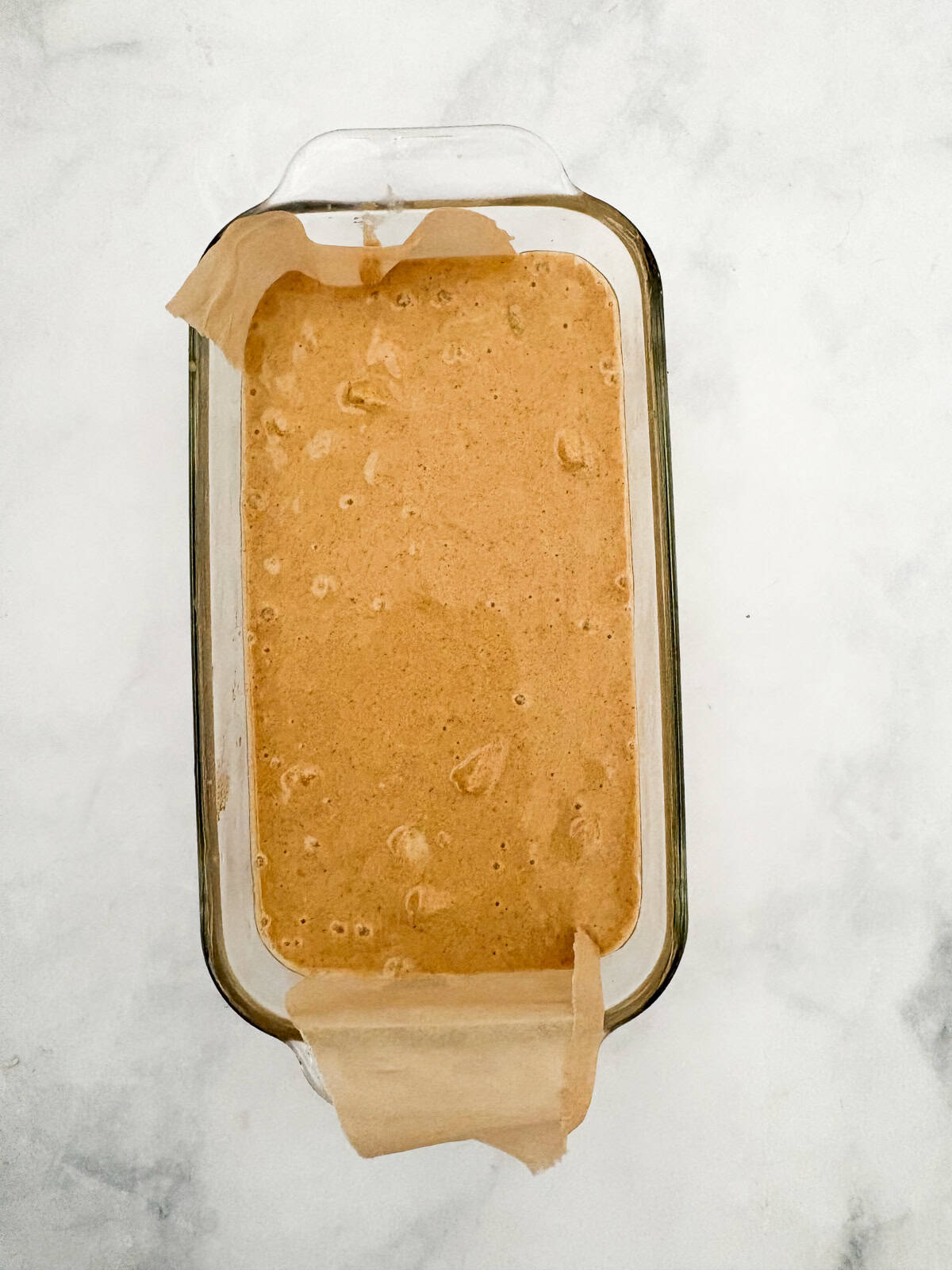 Juicy fresh peaches infuse this gluten-free peach quick bread with sweet summer flavor! Made with whole-grain oat flour and fresh fruit. A loaf pan filled with gluten free quick peach bread batter.