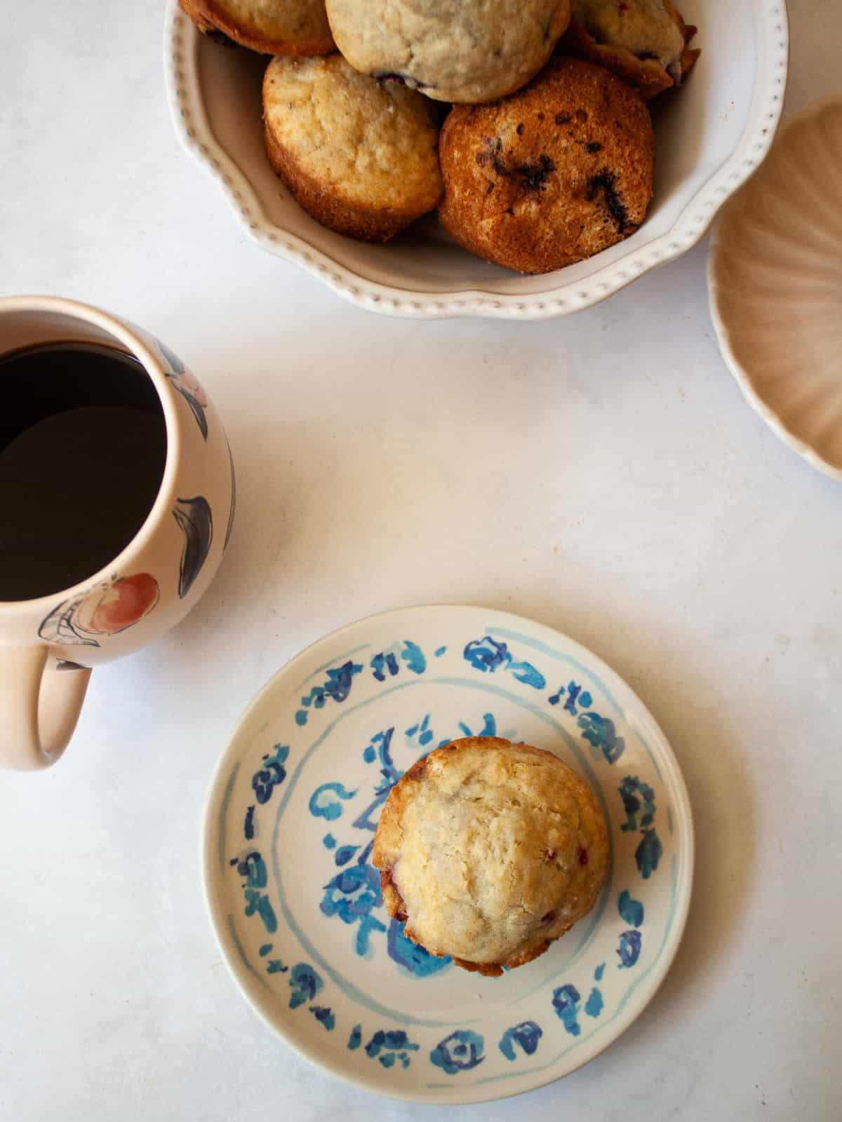 These delicious gluten-free raspberry muffins are made in one bowl and are packed with wholesome ingredients and fruit! A bowl of gluten free raspberry muffins and one on a plate.