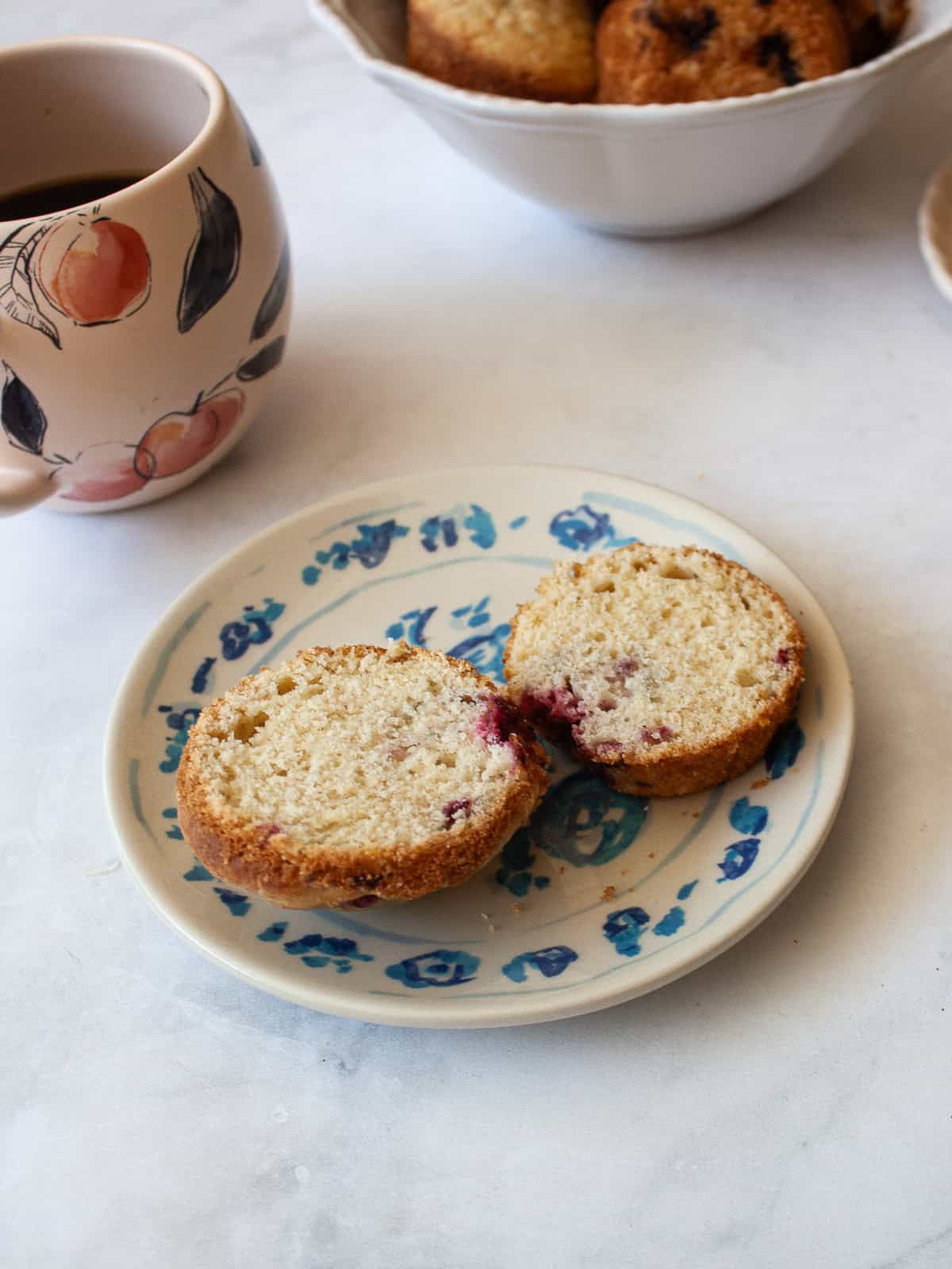 These delicious gluten-free raspberry muffins are made in one bowl and are packed with wholesome ingredients and fruit! A gluten free raspberry muffin that's been cut in half on a plate.