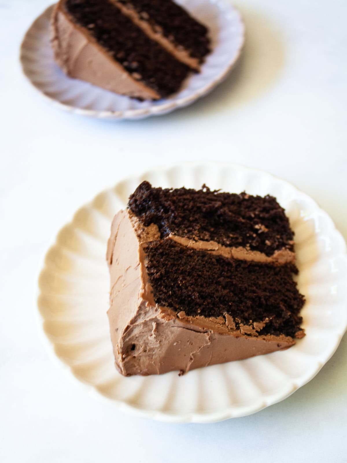 A two-layer higher protein chocolate cake slice on a plate.
