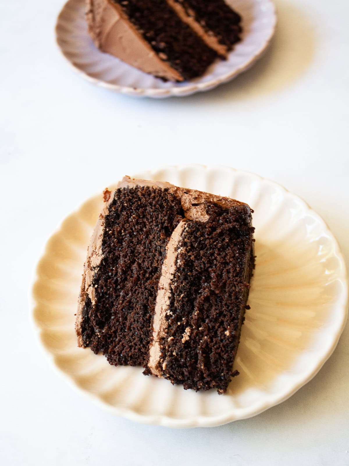This tender, naturally higher-protein chocolate cake delivers 8 grams of protein per slice from whole foods ingredients. NO protein powder! Slices of protein chocolate cake on plates.