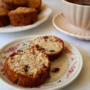 Two halves of a chocolate chip raspberry muffin on a plate.
