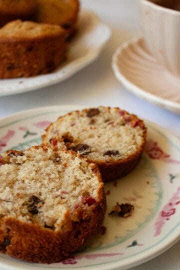 Two halves of a chocolate chip raspberry muffin on a plate.