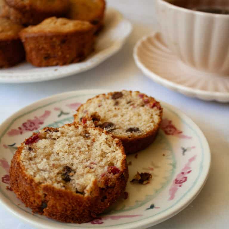 Two halves of a chocolate chip raspberry muffin on a plate.