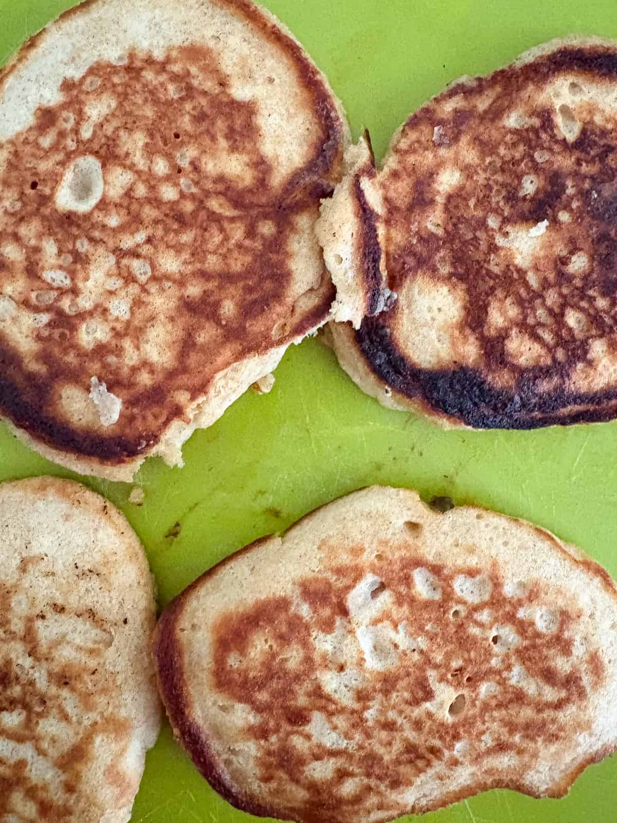 These strawberry pancakes feature fresh, juicy strawberries, whole grain flour, and a light and fluffy crumb. Gluten-free if needed. Cooked strawberry pancakes on a cutting board.