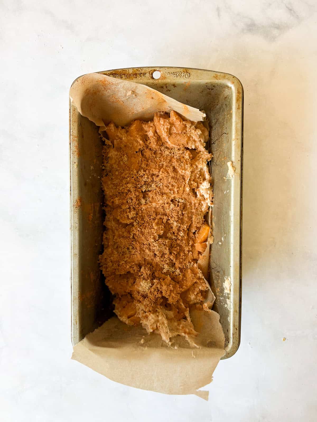 A crisp and cozy oat topping makes this whole grain peach bread shine! Featuring juicy bites of peaches and a brown sugar-cinnamon swirl. Cinnamon is added to peach bread batter.