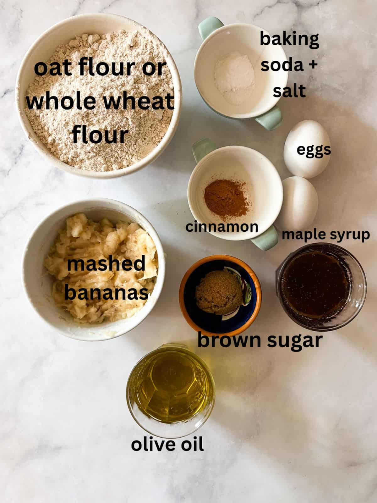 Simple and lightly sweet cinnamon banana muffins are made with wholesome ingredients and finished with a cap of cinnamon and brown sugar. Ingredients for cinnamon banana muffins are text-labeled.