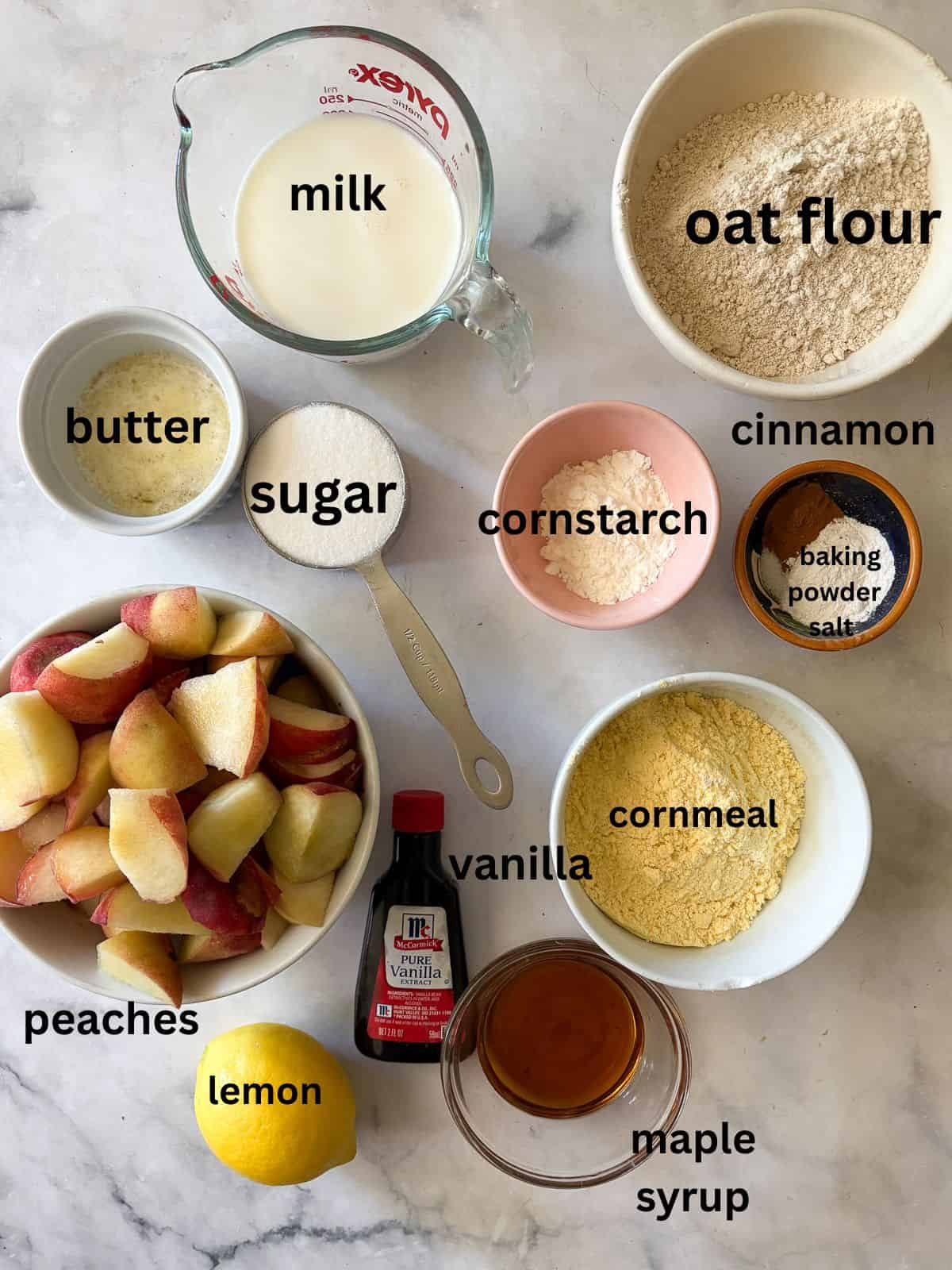 This gluten free peach cobbler features juicy peaches tucked into a pillowy gluten-free batter to make a rustic, simple dessert. Ingredients for gluten free peach cobbler are text-labeled.