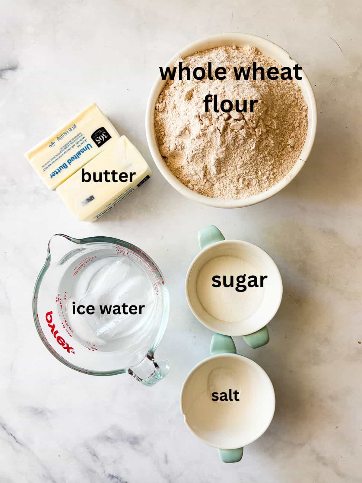 Whole grain flour adds nutrition and flavor to this flaky whole wheat pie crust. Use it in your favorite pies, galettes, and more. Ingredients for whole wheat pie crust are text-labeled.