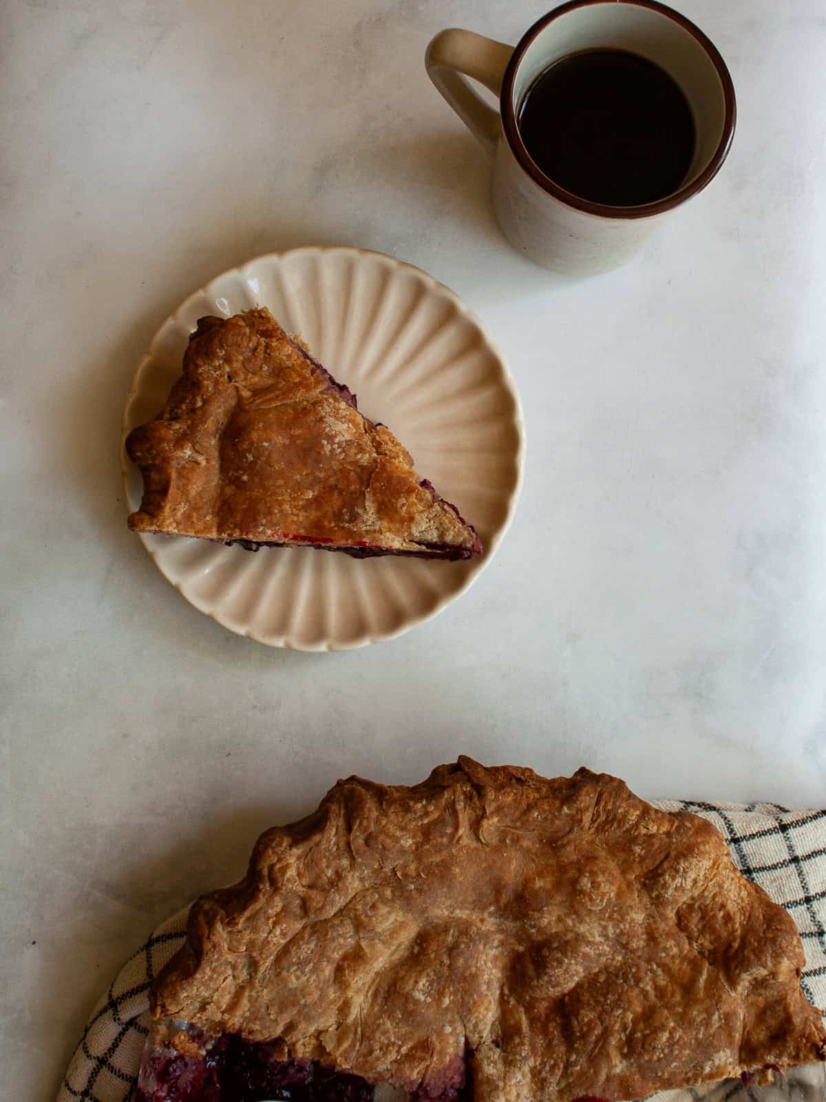 A simple method and ingredients makes this blackberry pie an easy, delicious summer bake. Make gluten-free or not, as needed! A slice of blackberry pie on a plate with the pie below it.