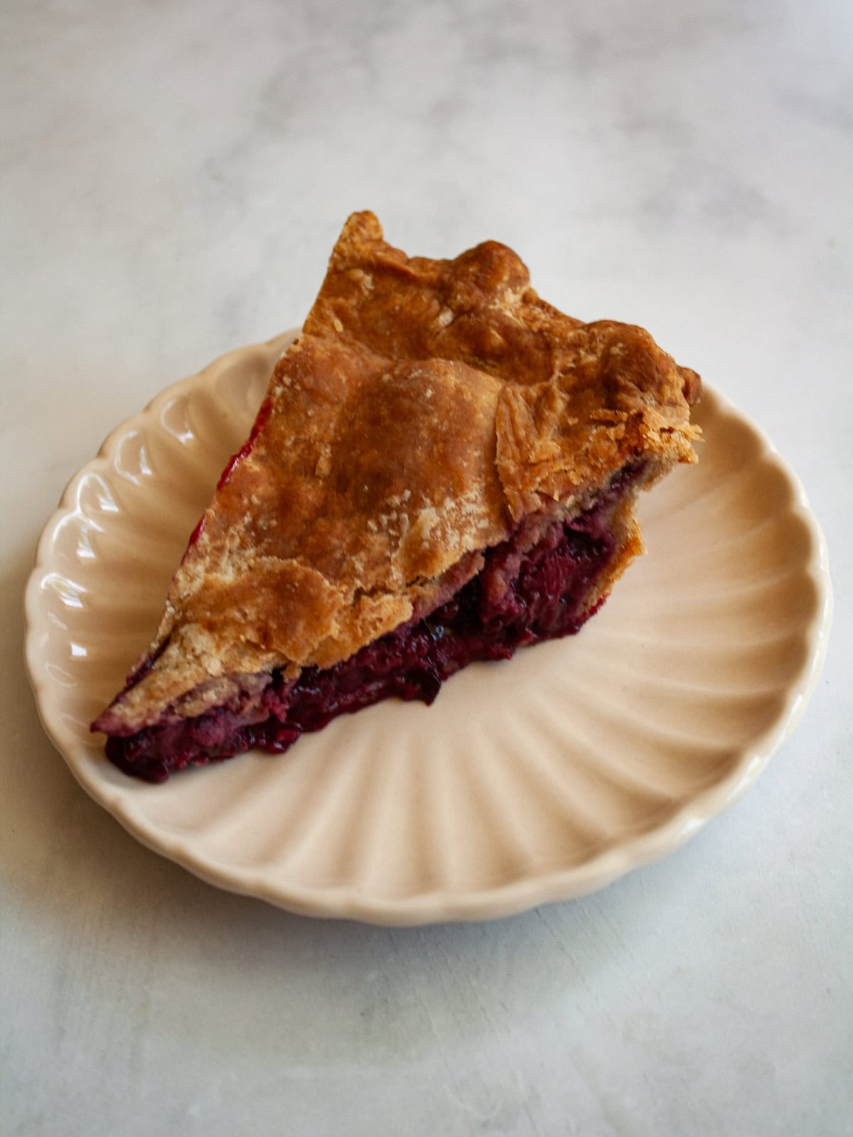 A simple method and ingredients makes this blackberry pie an easy, delicious summer bake. Make gluten-free or not, as needed! A thick slice of homemade blackberry pie on a plate.