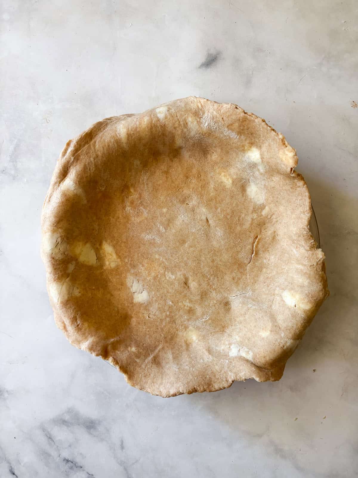 A classic method is used to make this blueberry blackberry pie, which features fresh summer berries folded into a tender crust. A bottom crust layer is fitted into a pie pan.