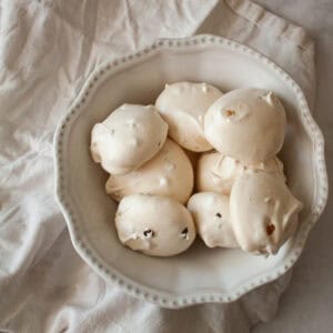 A bowl of chocolate chip meringue cookies on a napkin.
