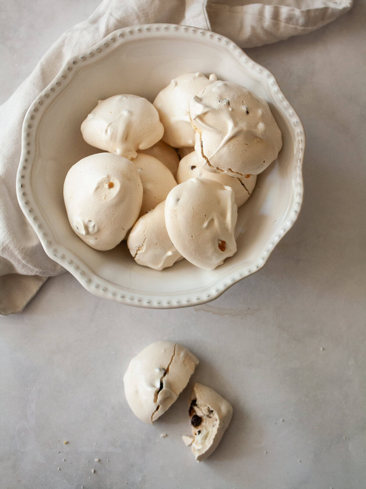 Marshmallowy chocolate chip meringue cookies are studded with mini chocolate chips for bursts of semisweet chocolate in every bite. A bowl of chocolate chip meringue cookies in a bowl.