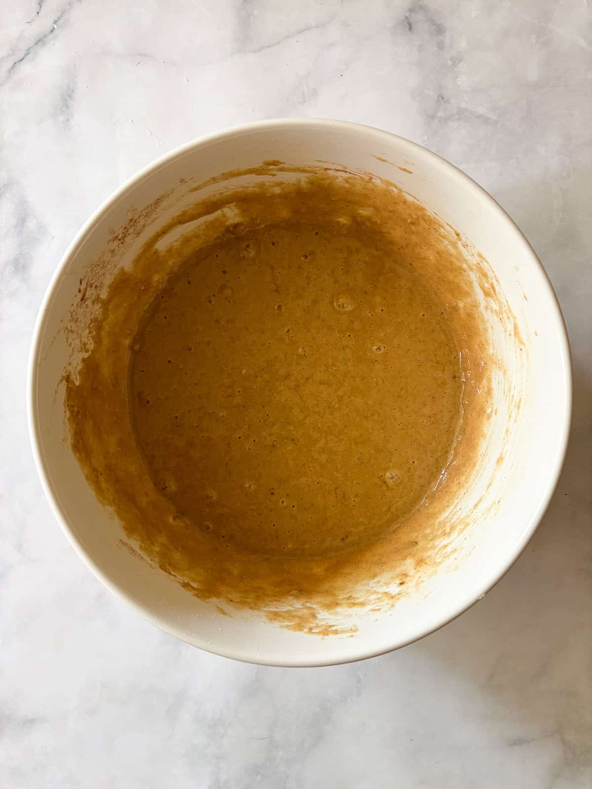 Simple and lightly sweet cinnamon banana muffins are made with wholesome ingredients and finished with a cap of cinnamon and brown sugar. The batter for cinnamon banana muffins in a bowl.