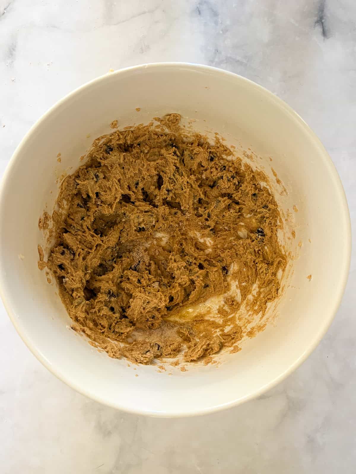 An easy gluten free batter packed with whole grains and yogurt makes for the best loaf of gluten free chocolate chip banana bread. The combined batter for gluten free chocolate chip banana bread in a bowl.