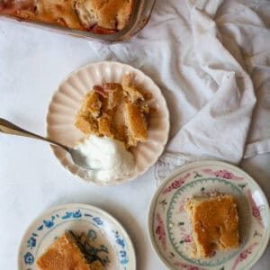 Three portions of gluten free peach cobbler next to the pan of cobbler.