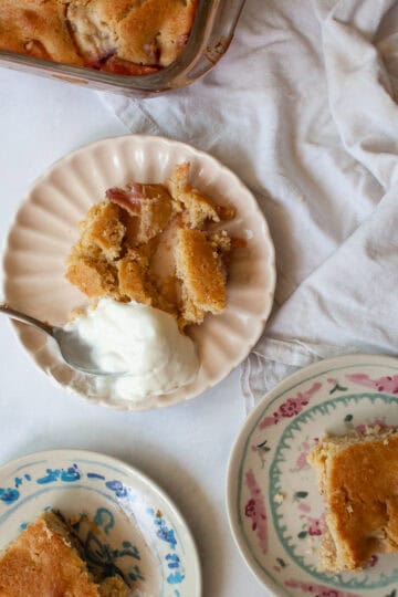 Three portions of gluten free peach cobbler next to the pan of cobbler.