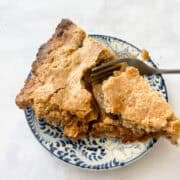 A slice of Gravenstein apple pie on a plate.