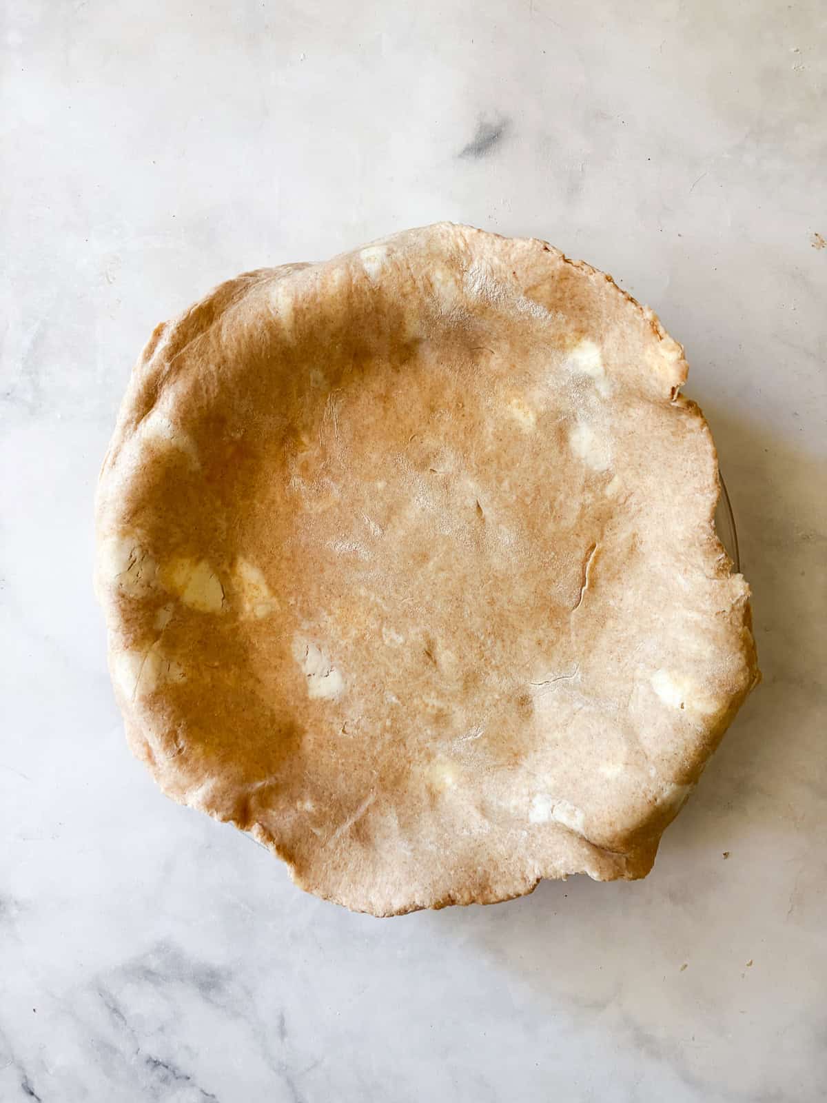 Whole grain flour adds nutrition and flavor to this flaky whole wheat pie crust. Use it in your favorite pies, galettes, and more. A whole wheat pie crust lines a pie pan.