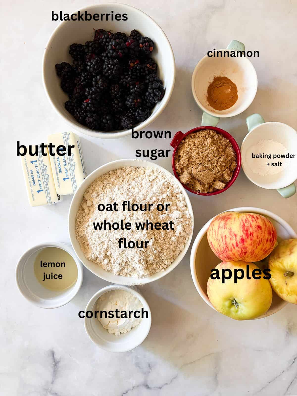 This delicious apple blackberry crumble stars juicy pockets of berries, sweet-tart apples, cinnamon, brown sugar, and a buttery topping. Ingredients for apple blackberry crumble are text-labeled.