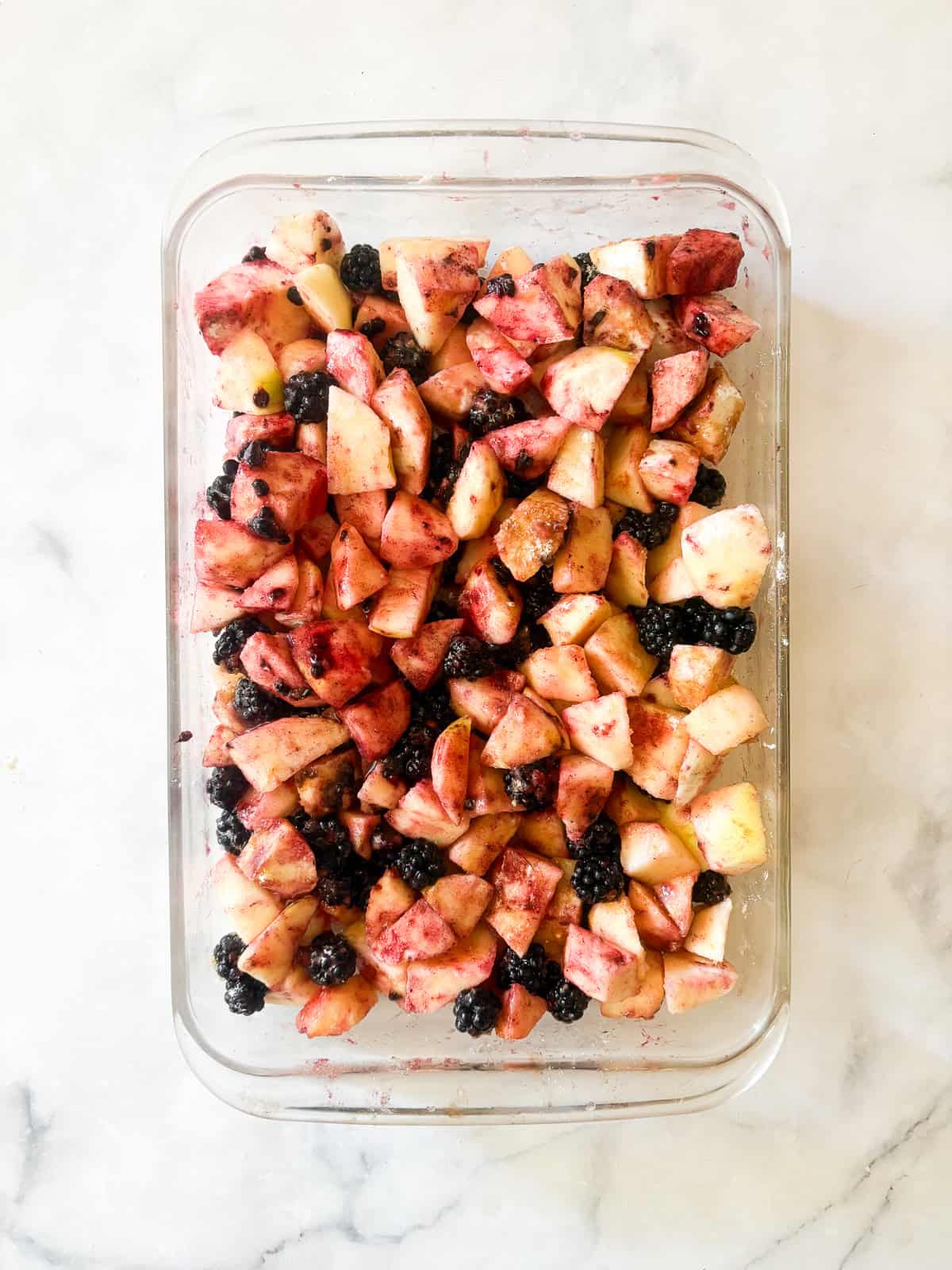 This delicious apple blackberry crumble stars juicy pockets of berries, sweet-tart apples, cinnamon, brown sugar, and a buttery topping. Apple and blackberries in a pan for apple blackberry crumble.