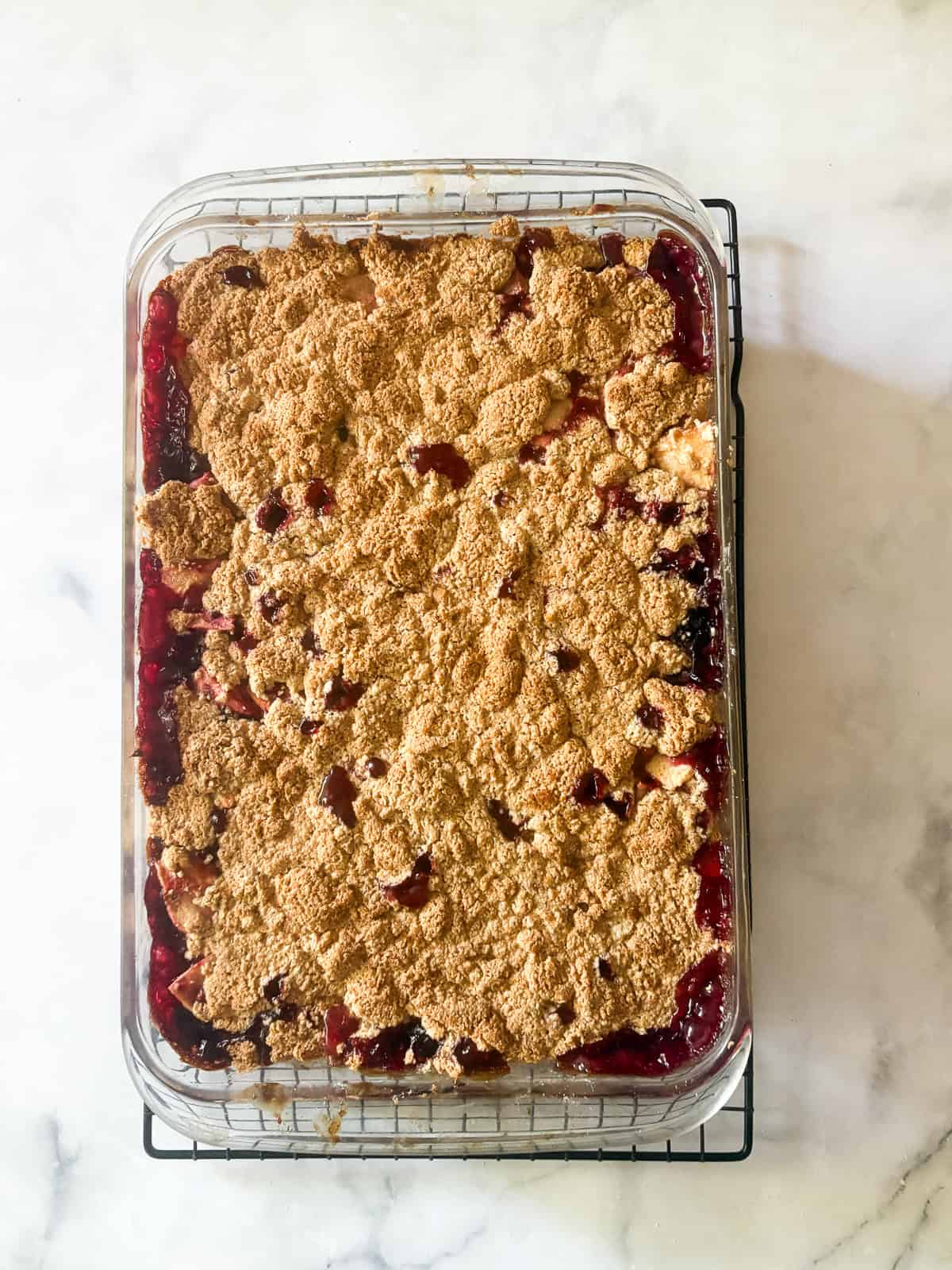 This delicious apple blackberry crumble stars juicy pockets of berries, sweet-tart apples, cinnamon, brown sugar, and a buttery topping. An apple blackberry crumble cools in the pan.
