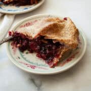 A side view of a piece of apple blackberry pie.
