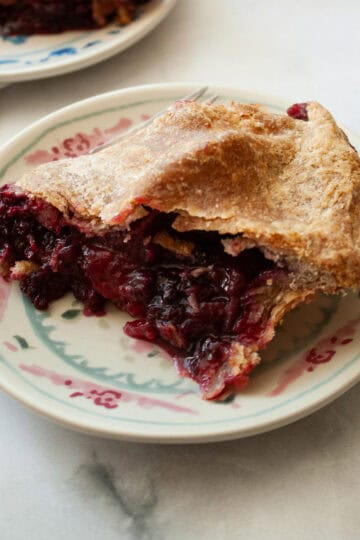 A side view of a piece of apple blackberry pie.