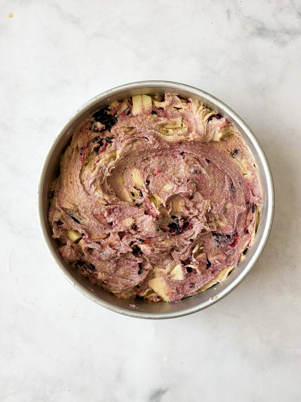 A simple and sweet blackberry apple cake that comes together in one bowl and can be made with g-f oat flour or whole wheat pastry flour. Blackberry apple cake batter in a cake pan.