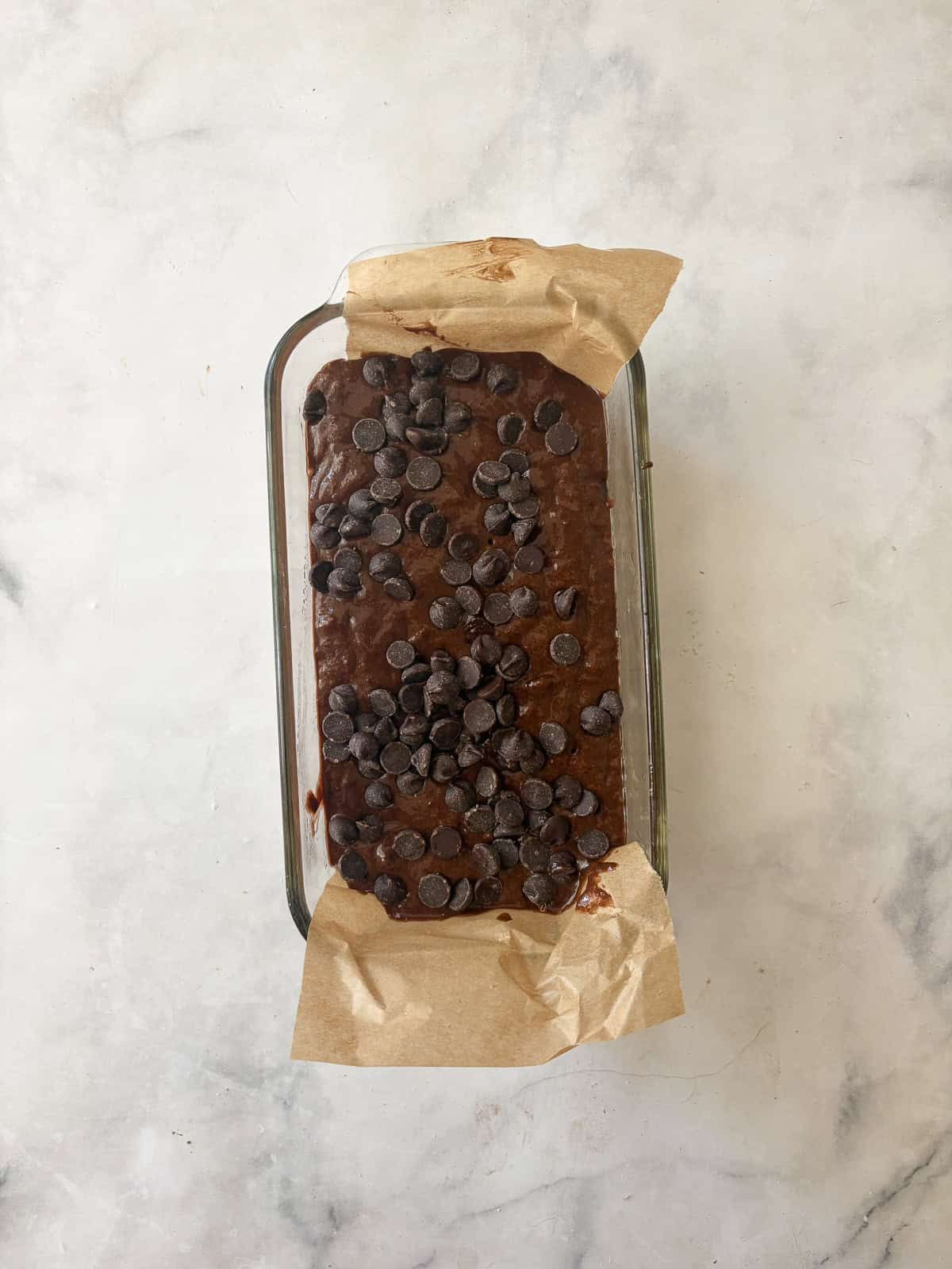 This rich, double chocolate banana bread can be made gluten free or with whole wheat flour for a dense, moist, and utterly delectable loaf. The batter for double chocolate banana bread is added to a lined loaf pan.