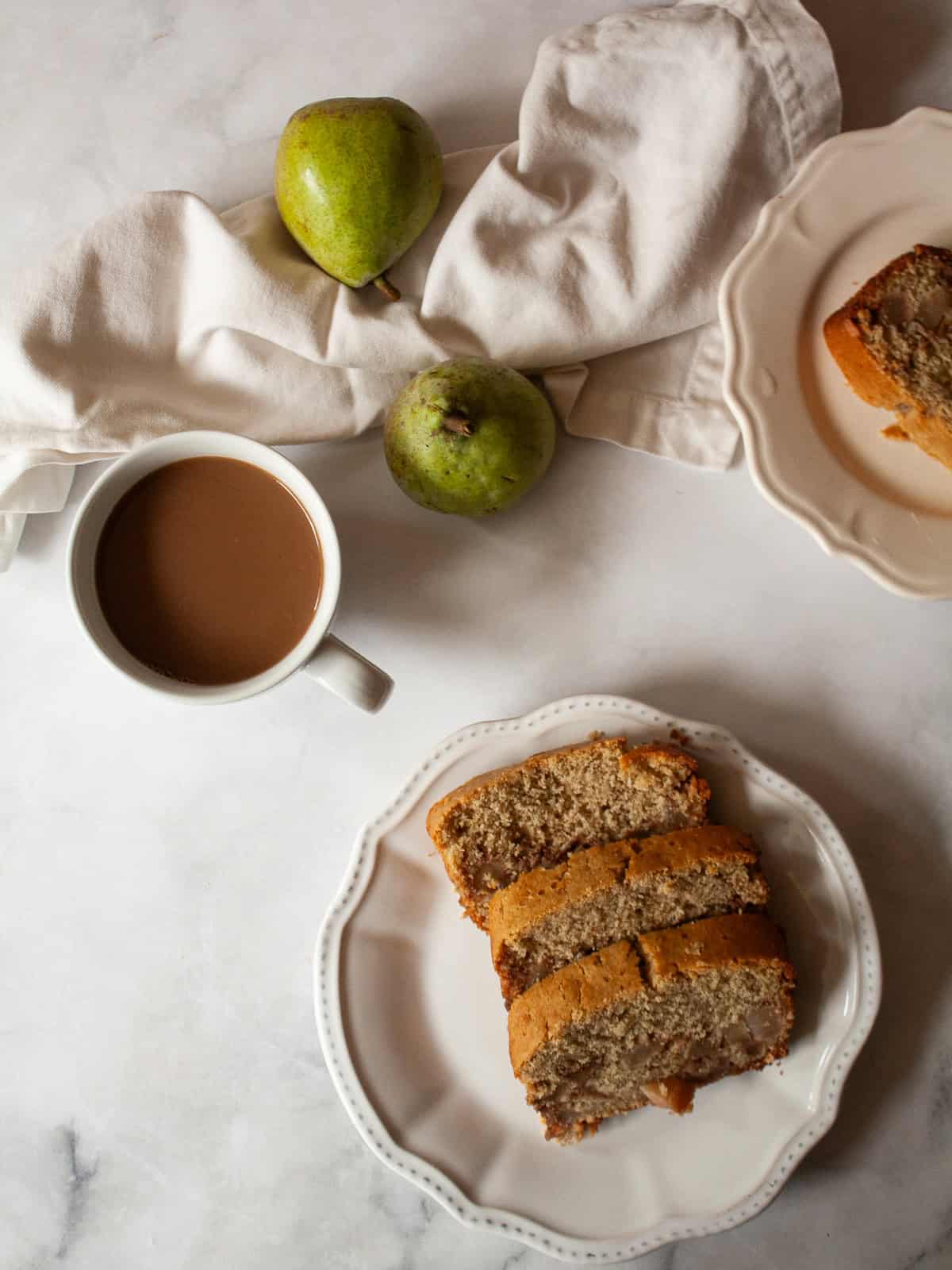 Pears, slices of pear bread, and a cup of coffee.