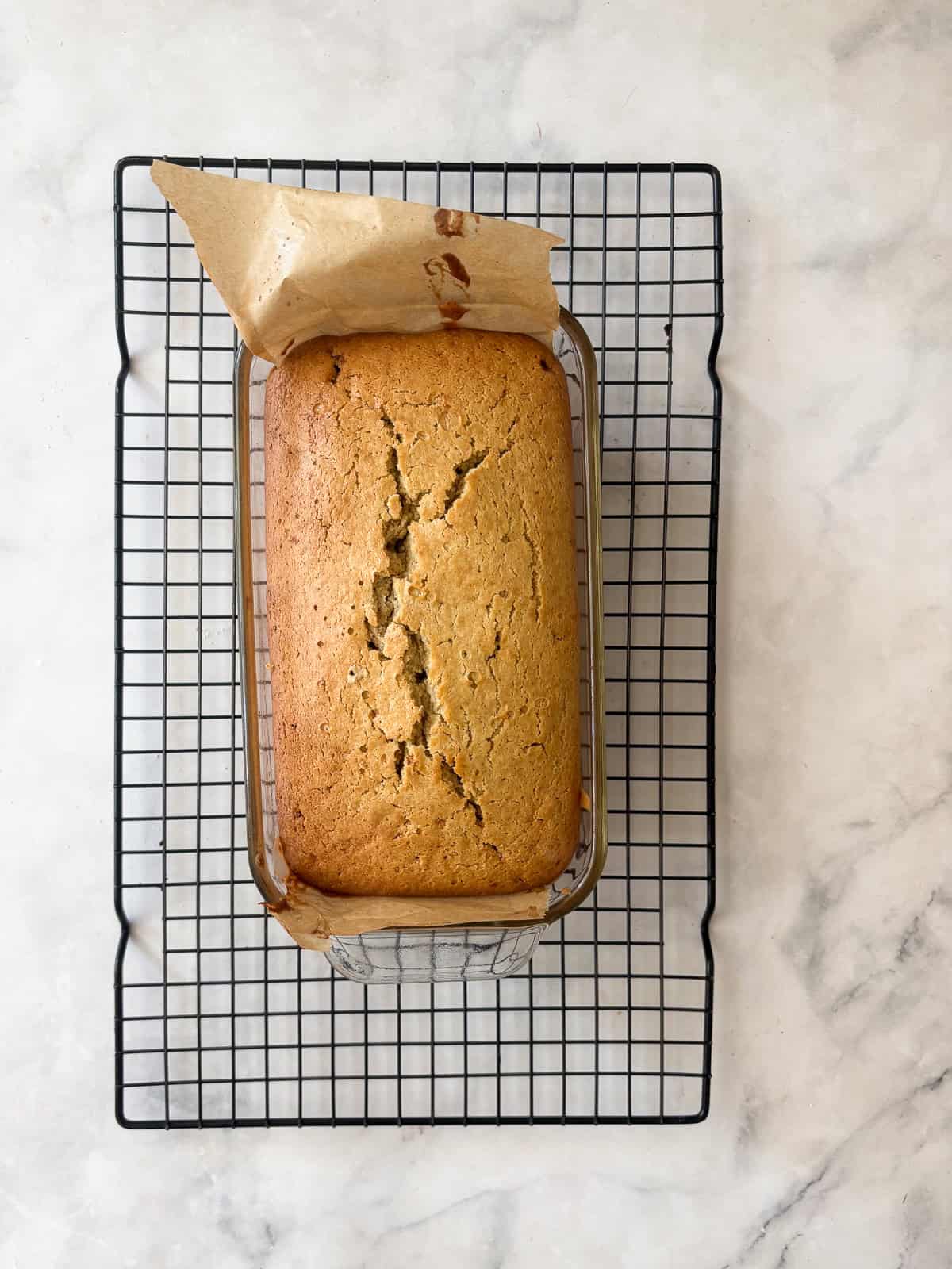 This one-bowl pear bread is a lovely sweet nibble, with a cozy mix of cinnamon and brown sugar-laced chopped pears in a whole grain loaf. A baked loaf of pear bread cools on a rack.
