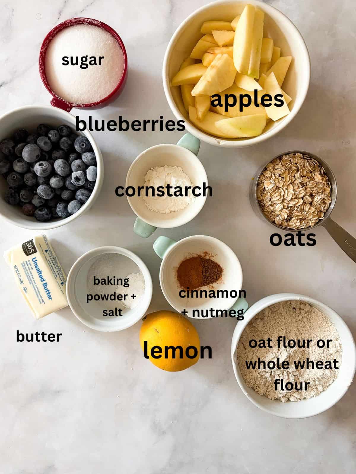 This apple blueberry crisp combines juicy summer apples and berries under a buttery oat topping. A seasonal dessert that's delicious warm. Ingredients for apple blueberry crisp are text-labeled.