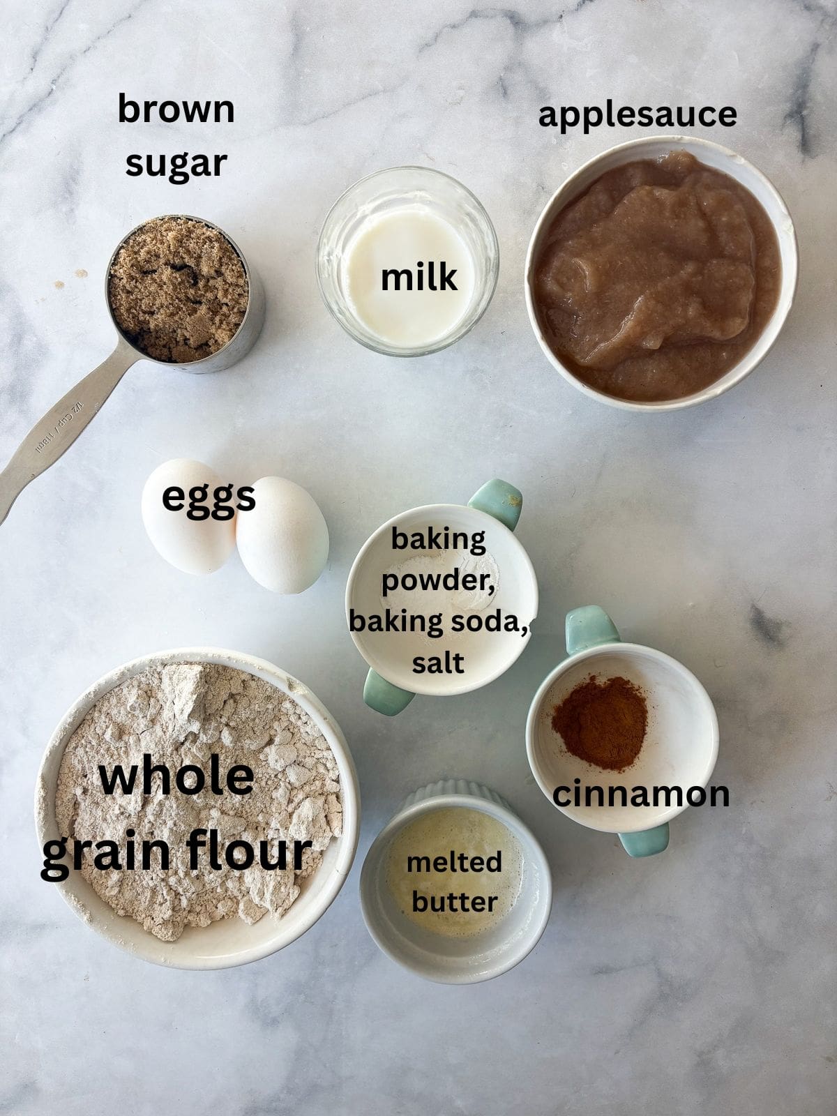 Simple and wholesome, these whole grain applesauce muffins are packed with unsweetened applesauce. Easy to make gluten-free, dairy-free, etc. Ingredients for applesauce muffins are text labeled.