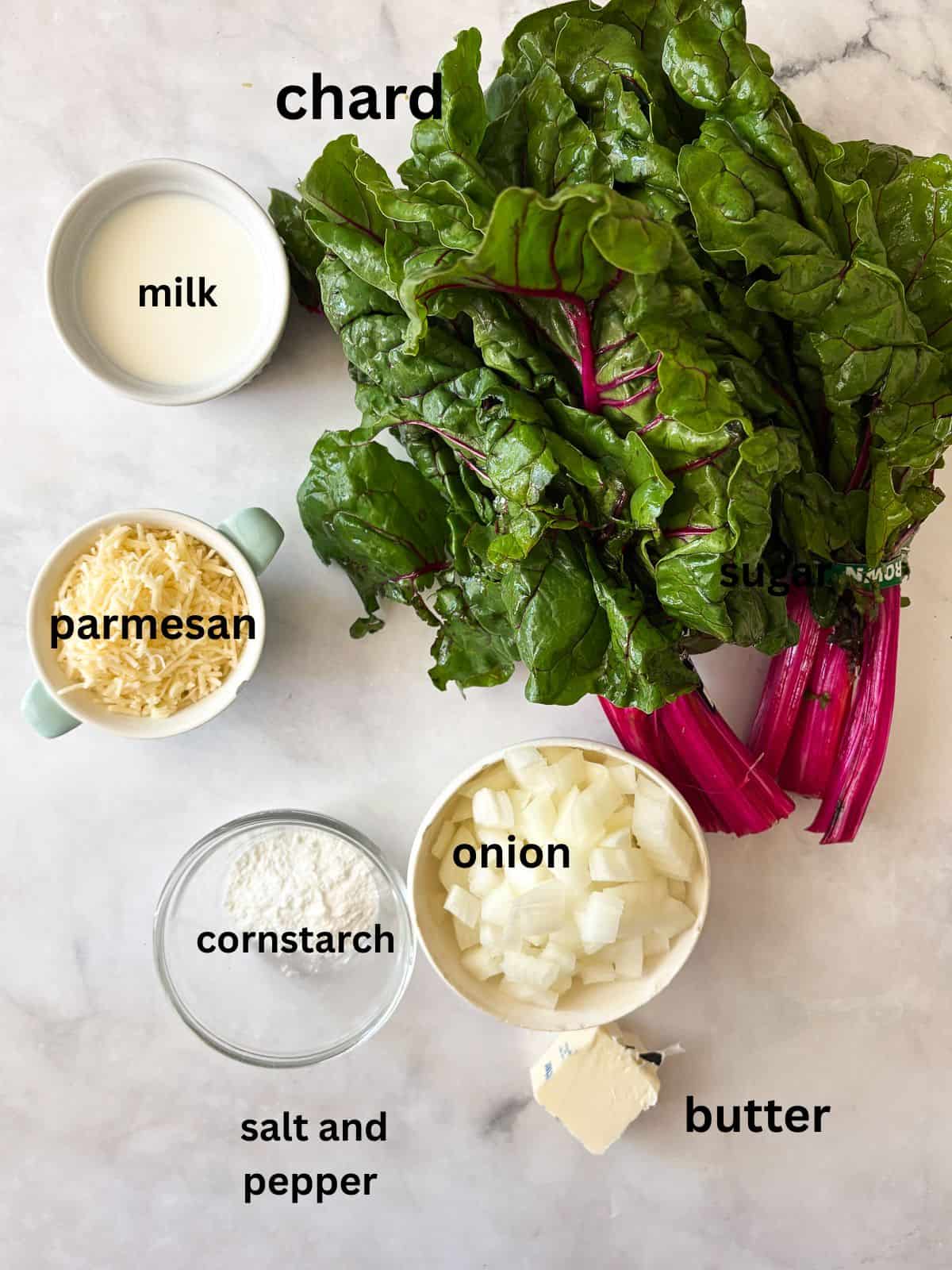 This easy chard gratin is a naturally gluten-free, vegetarian side dish made with fresh chard, onion, cheese, and milk. Perfect for fall and winter. Ingredients for chard gratin are text-labeled.